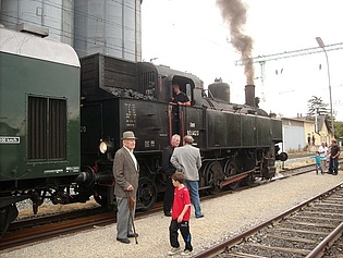 Personen stehen bei Führerstand der Dampflokomotive - in Lightbox öffnen